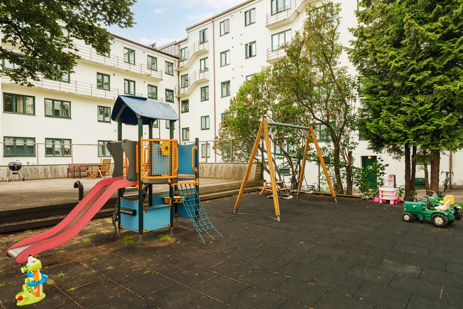 Enkel adkomst til en stor og herlig bakgård med to store plattinger, beplantning, utemøbler, lekestativ m.m. Galleribilde