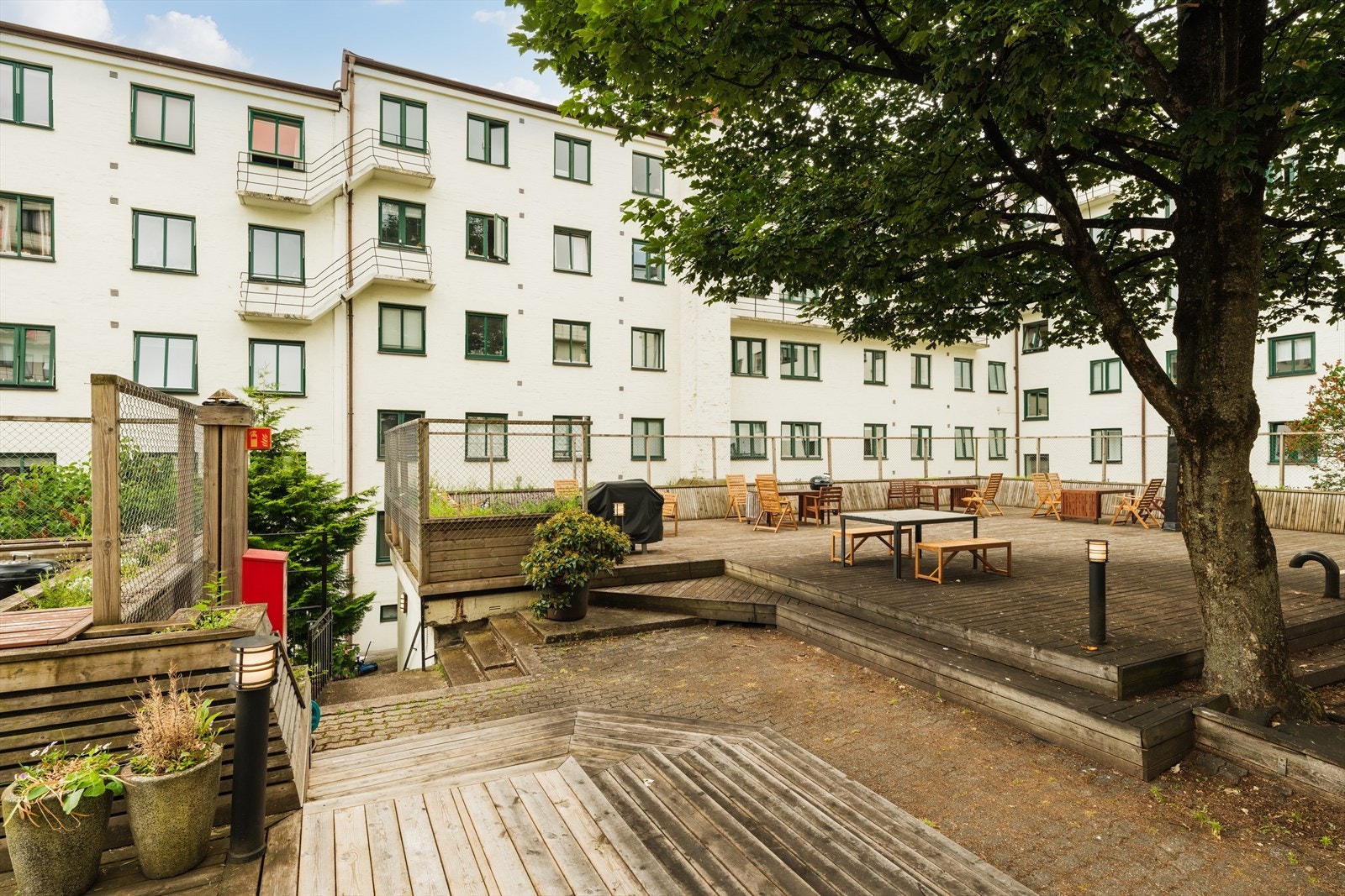 Enkel adkomst til en stor og herlig bakgård med to store plattinger, beplantning, utemøbler, lekestativ m.m. Galleribilde