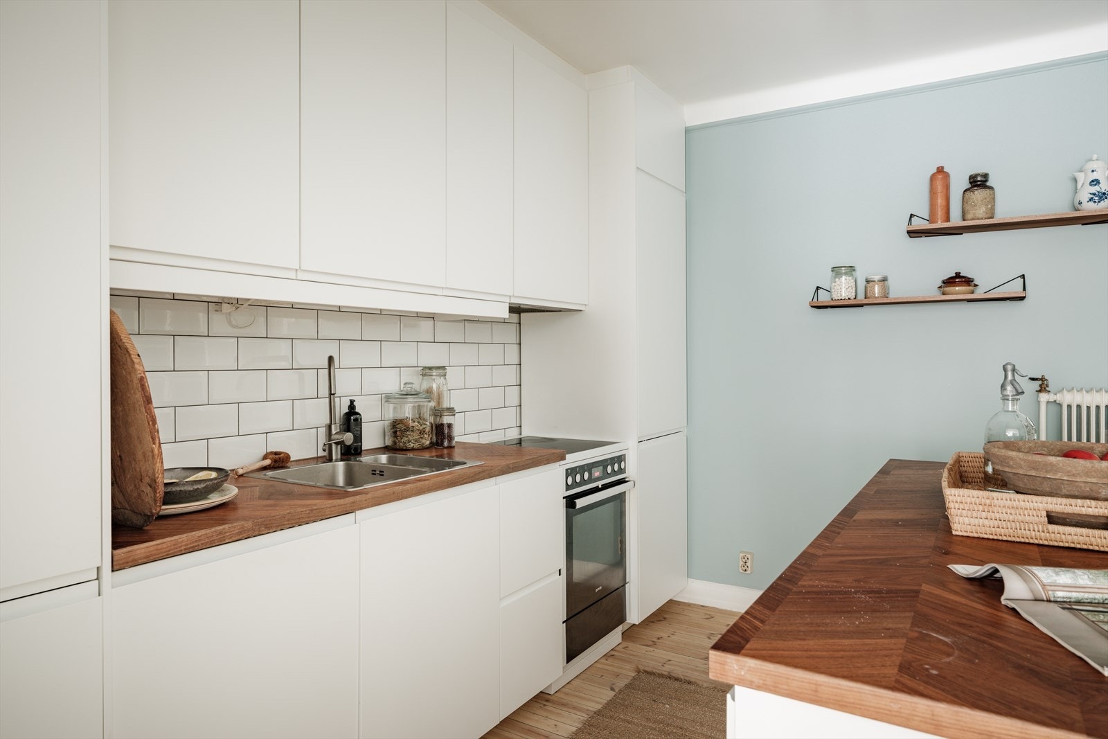 Stort kjøkken med tidløs innredning fra 2019. Kjøkkeninnredning med finerte benkeplater, slette skapfronter og flislagt backsplash.
Integrerte hvitevarer og frittstående komfyr/platetopp. Galleribilde
