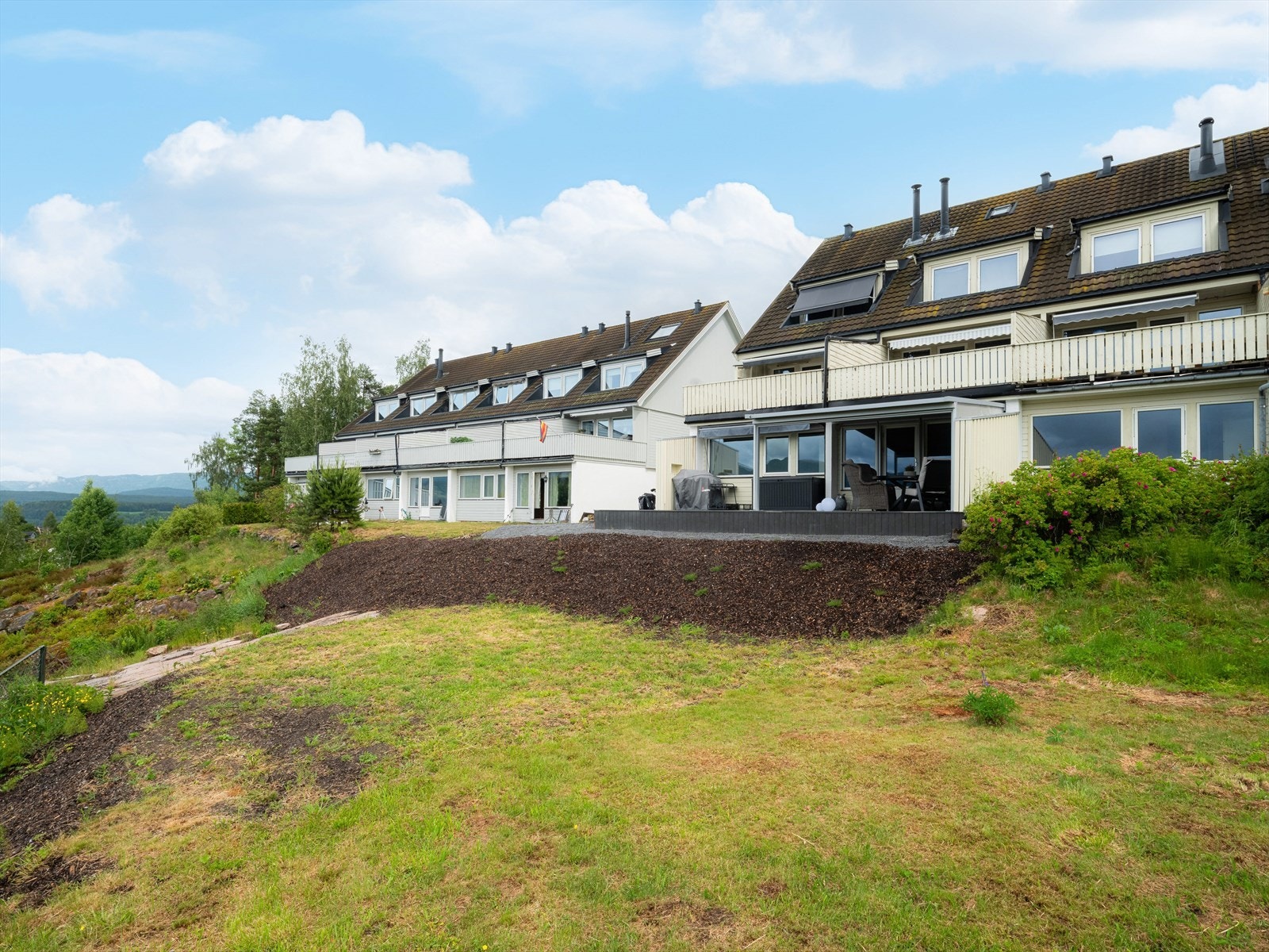 Sameiets tomt er pent opparbeidet med gressplen, busker og trær. Det er asfalterte gangstier, kjøreveier og parkeringsplasser. Galleribilde