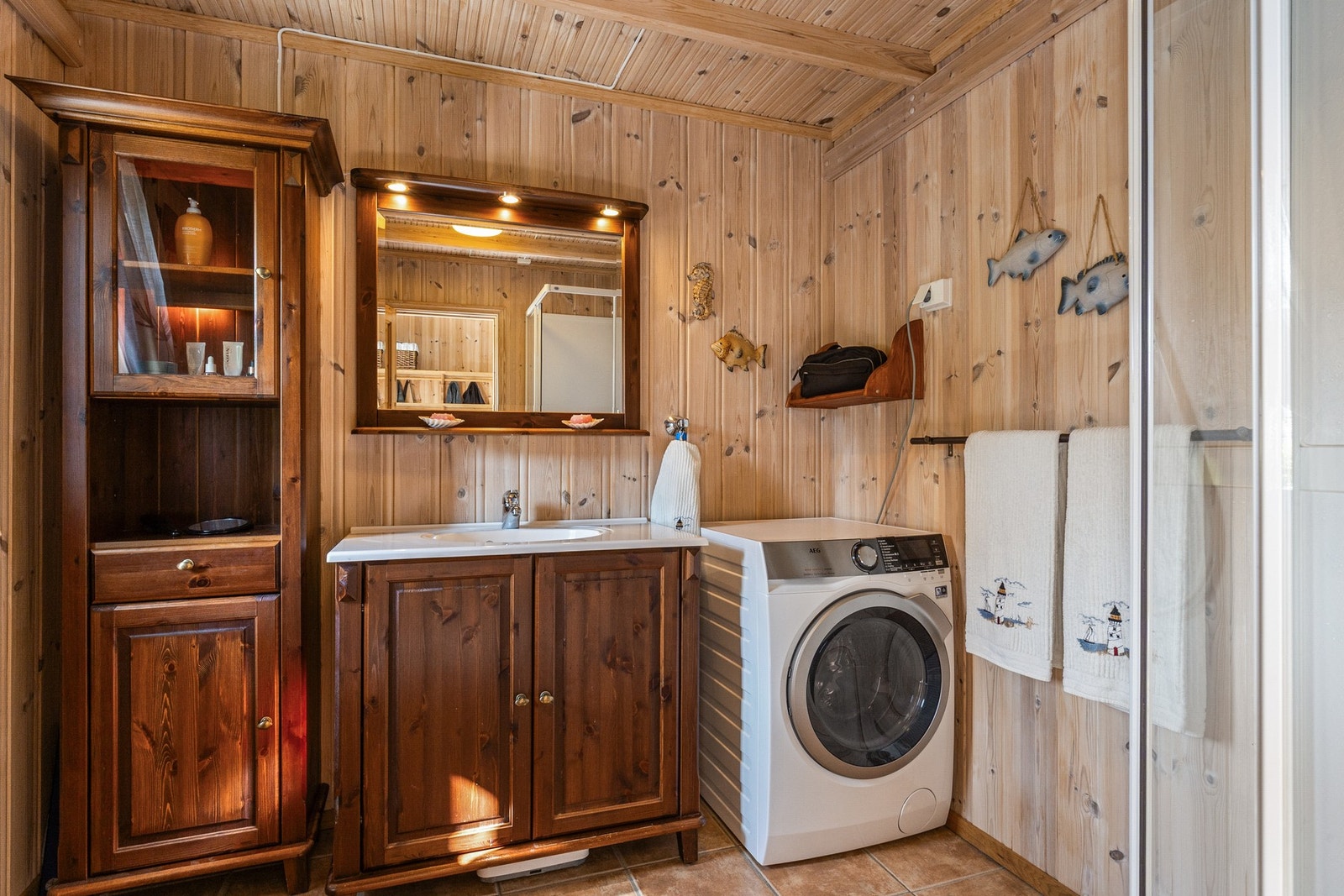 Bad med gulvmontert toalett, dusjkabinett og opplegg for vaskemaskin Galleribilde