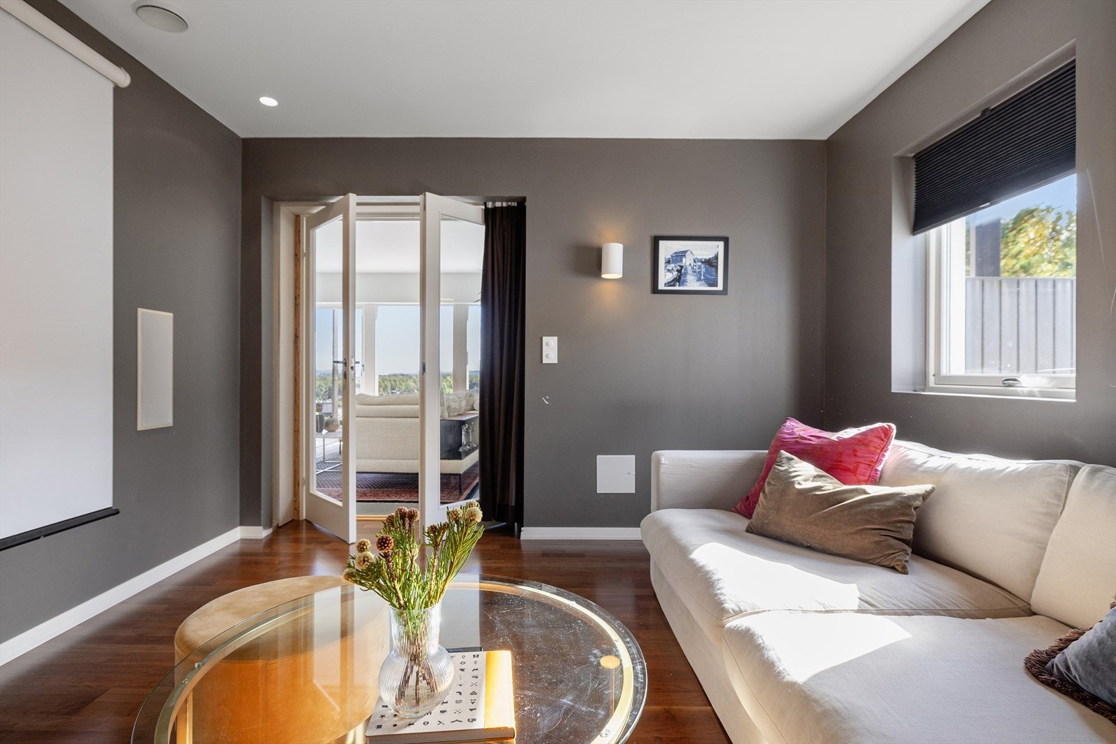 Inne på tv-stuen prydes gulvet av en vakker, eksklusiv valnøttparkett. Dette rommet kan bli en viktig samlingsplass for familien der det å se i fellesskap blir tilført kvalitet og egenverdi. Galleribilde