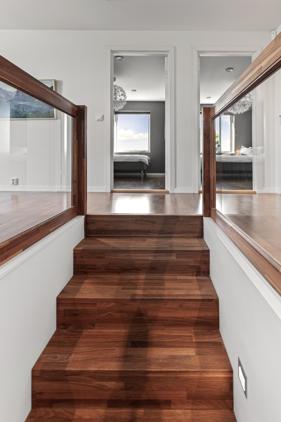 Ovenpå fortsetter valnøtten i den lekre, dype parketten. Legg merke til det solide rekkverket med innfelt glass! Galleribilde