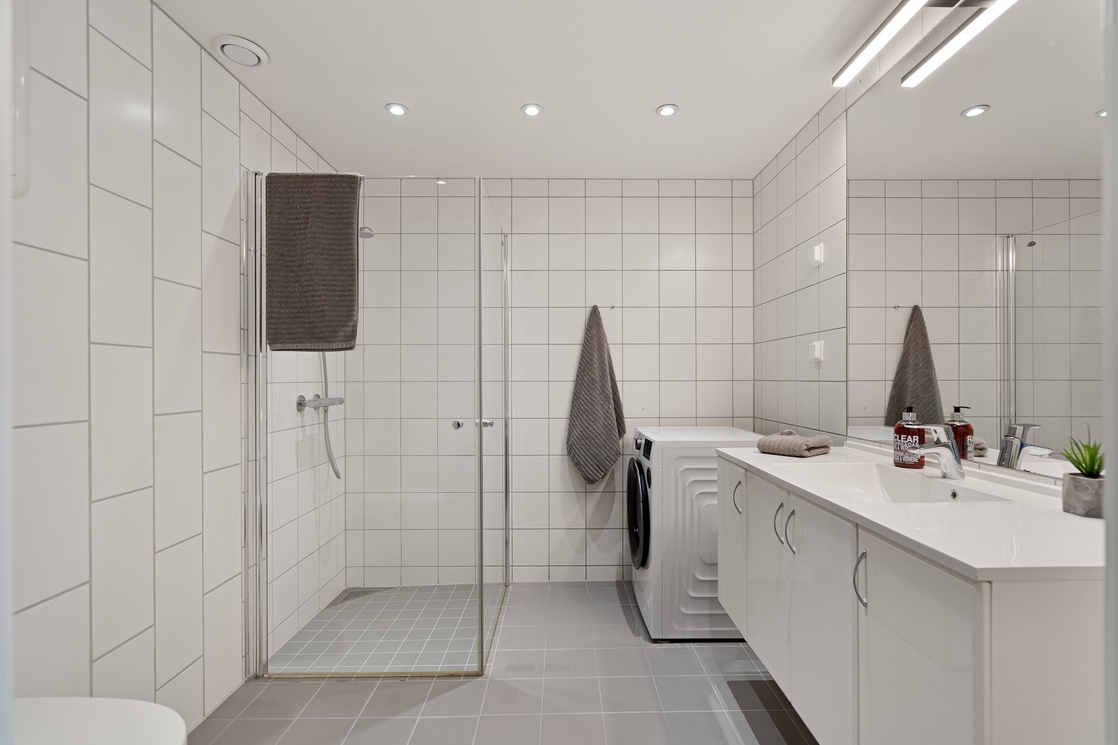 Stort flislagt bad med downlights i tak Galleribilde