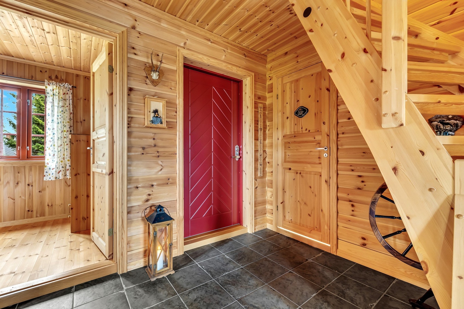 Du ønskes velkommen inn i en svært hjemmekoselig og innbydende hytte med fliser i entréen og tømmerpanel på veggene. Galleribilde