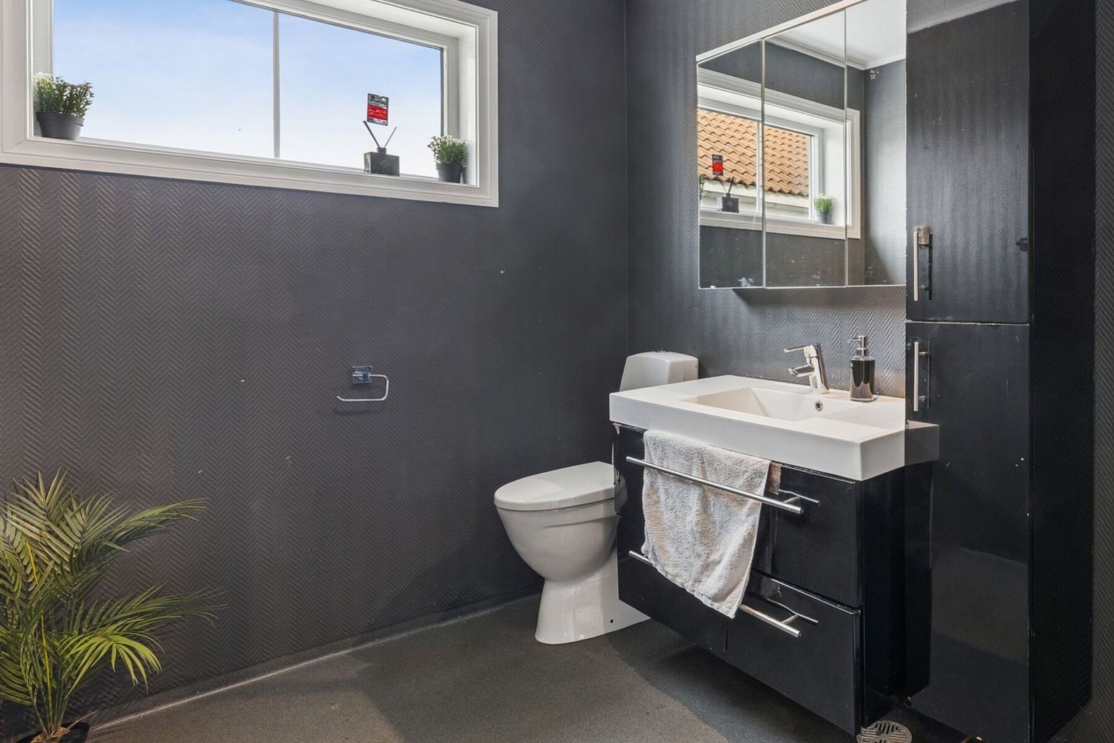 Badet er innredet med servant med underskap og speil, dusjkabinett, samt gulvmontert toalett. Galleribilde