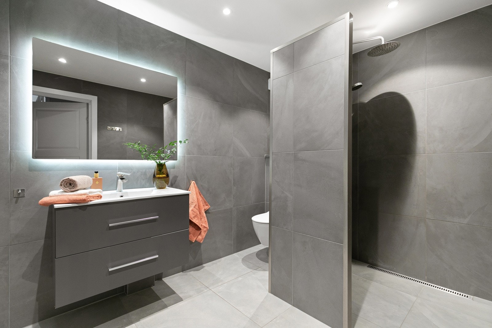 Badet er i 1. etasje ble renovert i 2018 og er flislagt med lekre grå fliser. Det er laget til dusjsone, vegghengt toalett og vegghengt servant med underskap. Galleribilde