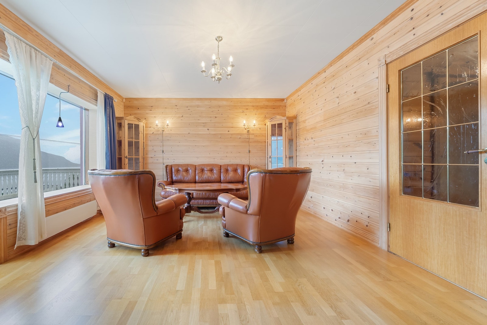 Stue med parkettgulv og furukledning på vegger. Galleribilde