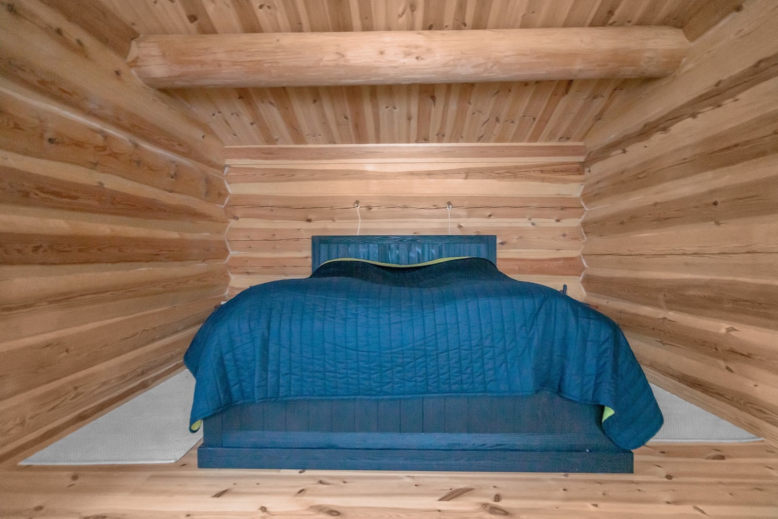 Koselig soverom med tømmervegger som gir en varm, naturlig atmosfære. Perfekt for avslapning og en god natts søvn. Galleribilde