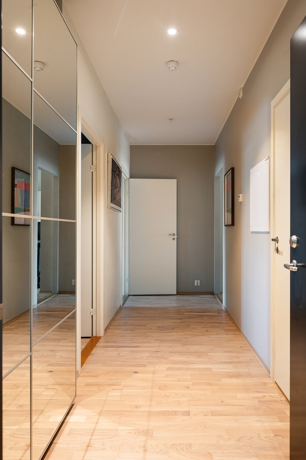 Leilighetens entré er lys og innbydende og gir et meget godt førsteinntrykk av boligen. Rikelig med oppbevaringsplass i en romslig skyvedørsgarderobe med speilfronter. Galleribilde