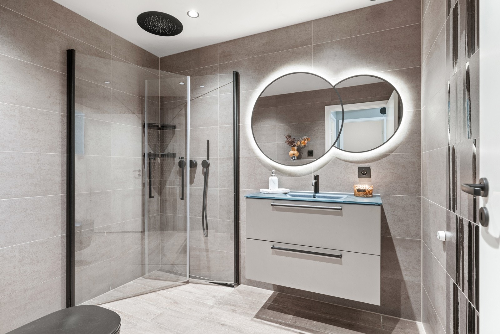 Overflater er belagt med senket, malt gipshimling med innfelte downlights og flislagte veggflater. Galleribilde