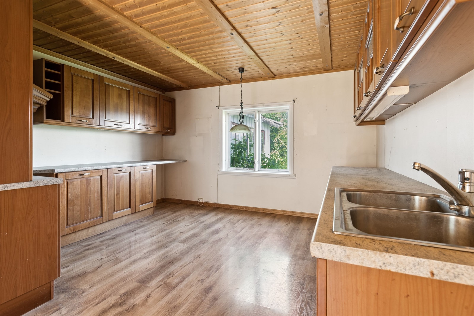 Kjøkkenet har en tosidig innredning med profilerte fronter og laminatbenkeplate. Galleribilde