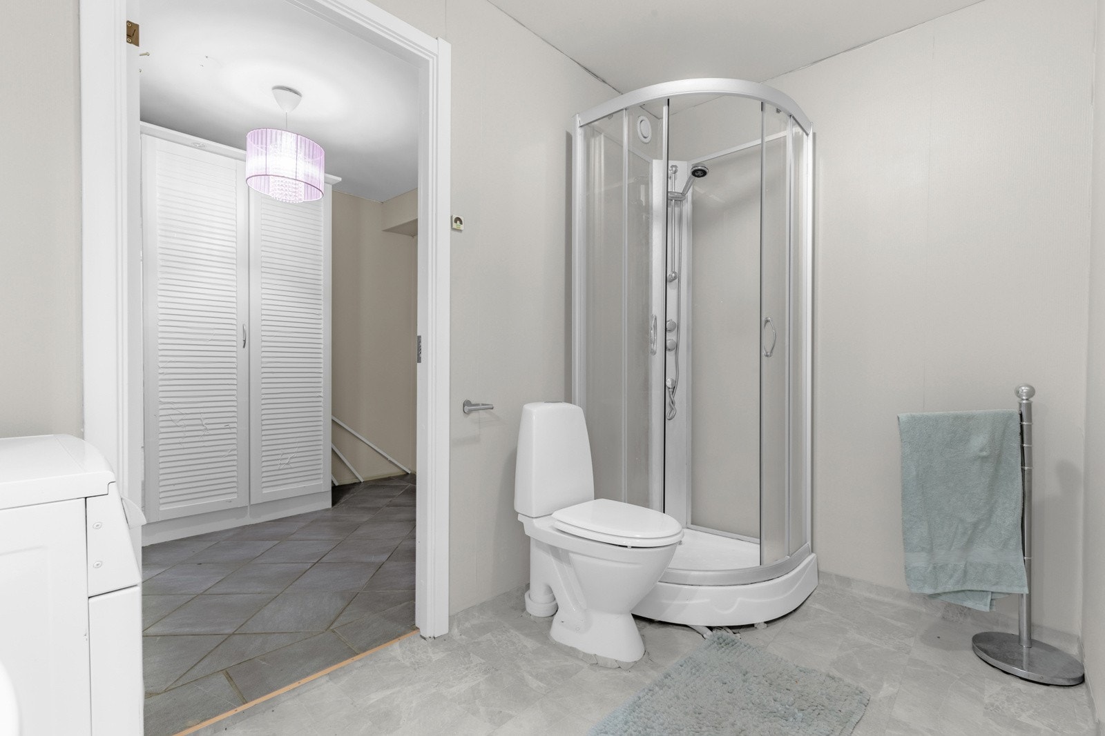 Baderommet inneholder vegghengt servant med profilerte, lyse fronter, heldekkende servant, speilskap med belysning og stikkontakt, toalett og dusjkabinett. Galleribilde