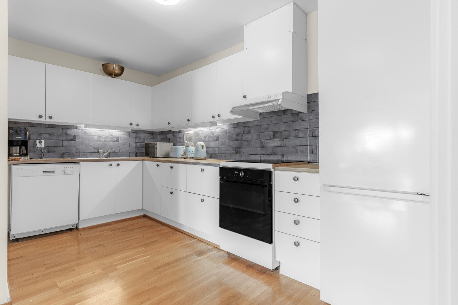 Kjøkkenet har lyse, glatte fronter, samt benkeplate av laminat. Galleribilde