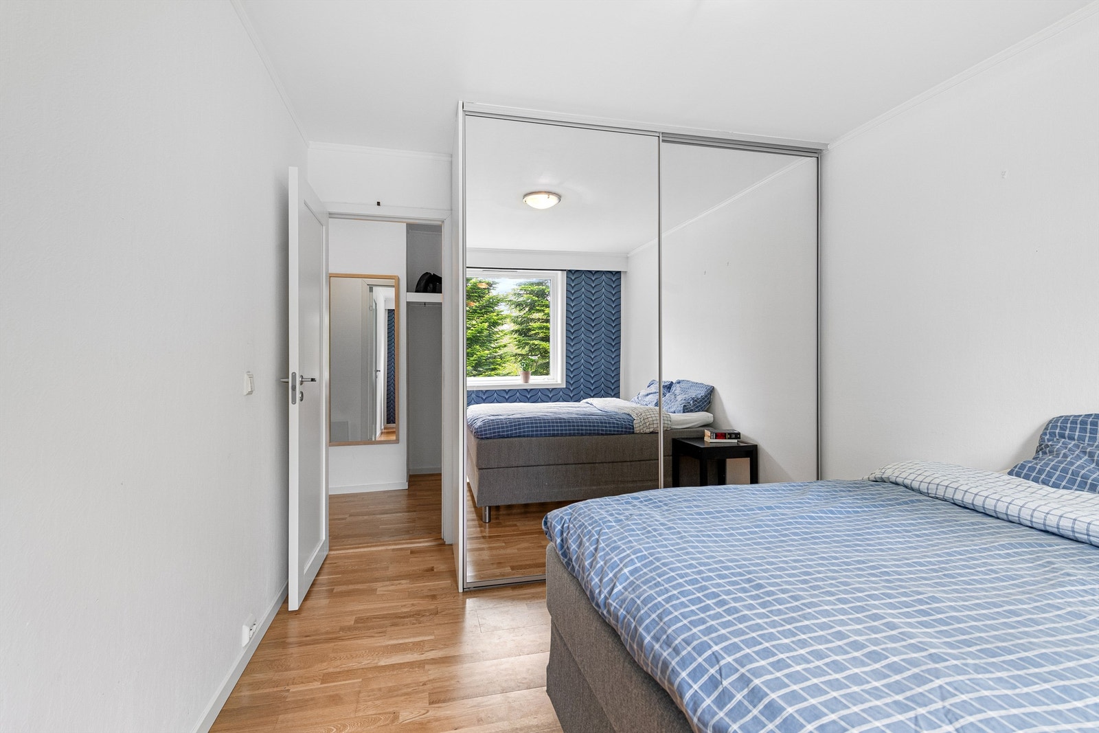 Skyvedørsgarderobe med speilfronter på soverommet som gir en god romfølelse Galleribilde