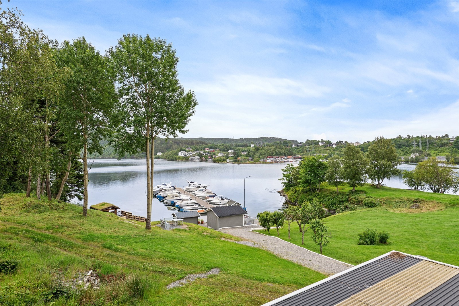 Utsikt fra balkongen mot fjorden, småbåthavna og flotte fellesområder i borettslaget Galleribilde