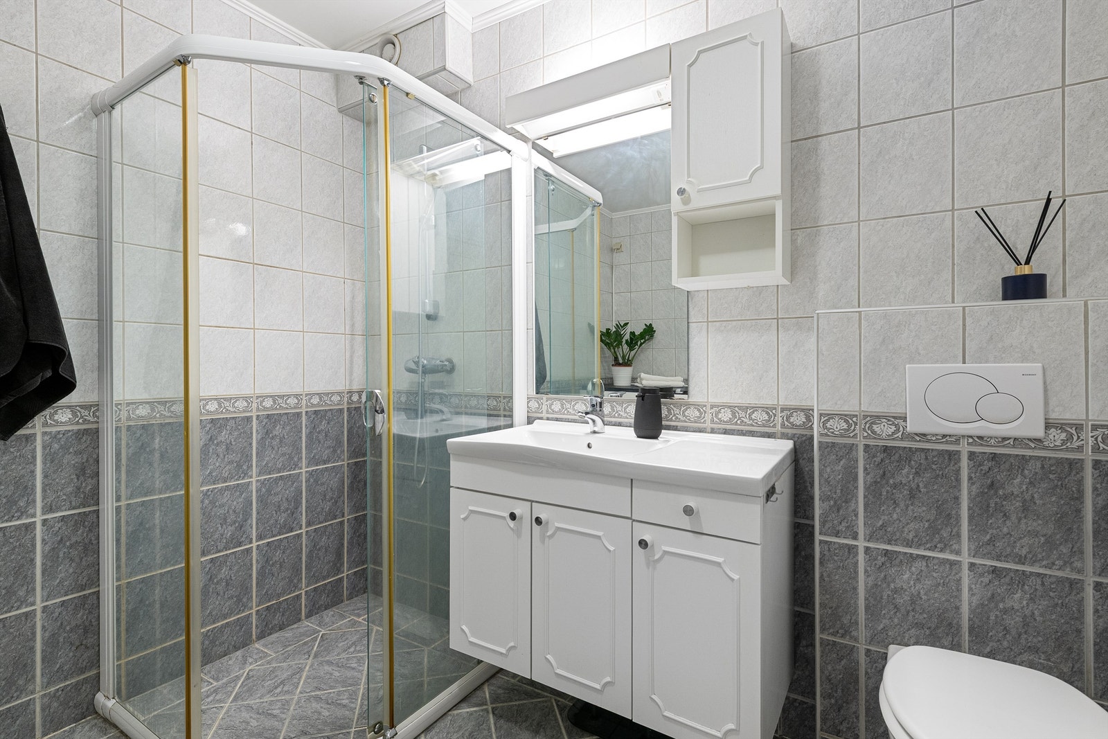 Dusjhjørne med vegghengt dusjarmatur, innredning med speil og overlys. Vegghengt wc Galleribilde