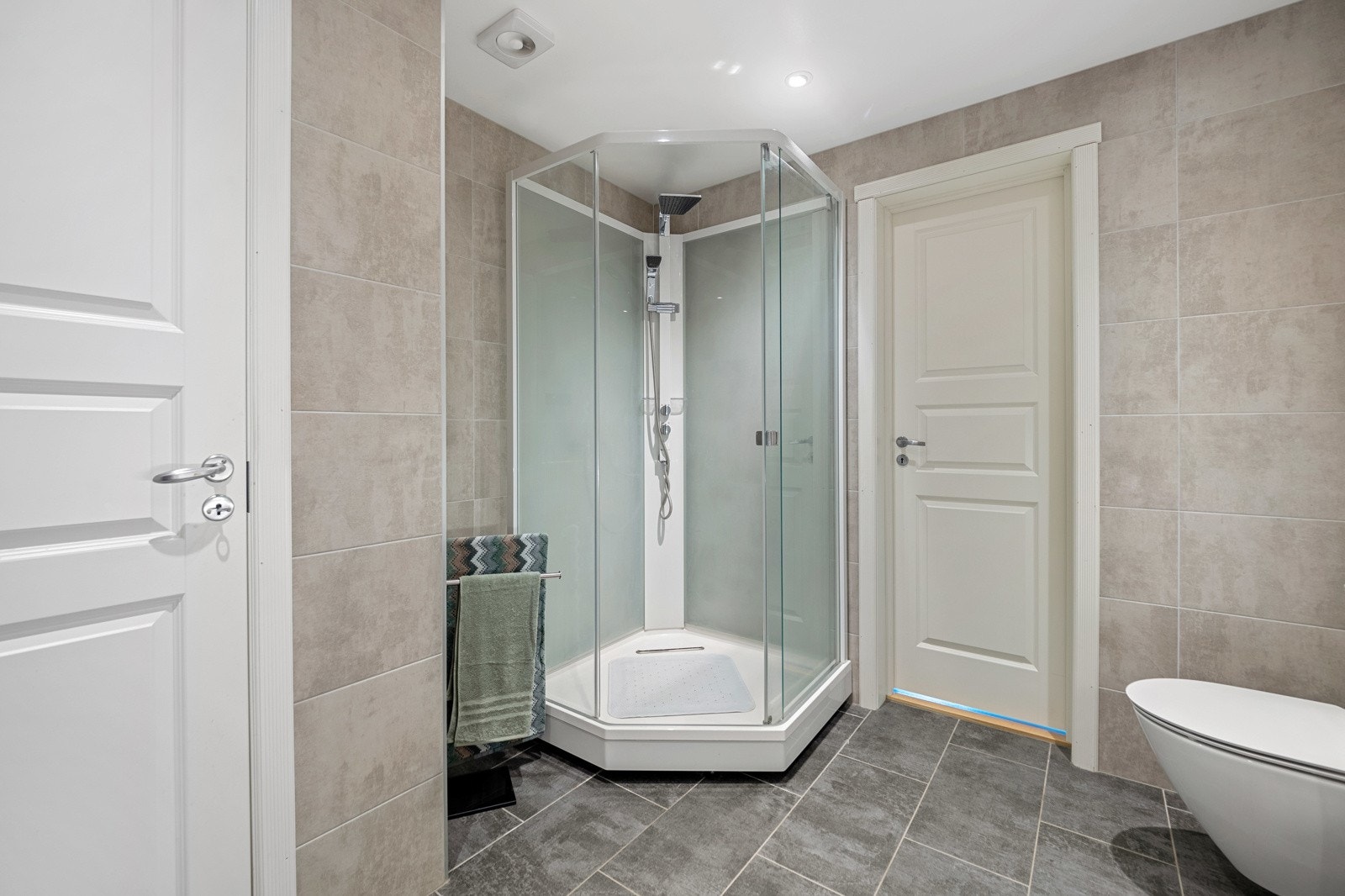 Dusjkabinettet har både hånddusj og regnfallsdusj. Badet har også veggmontert toalett og god skapplass. Galleribilde