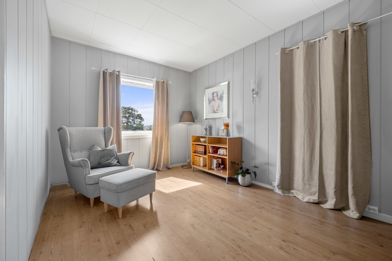 Loftstuen har sydvendt vindu, laminatgulv og gråmalte veggflater. Galleribilde