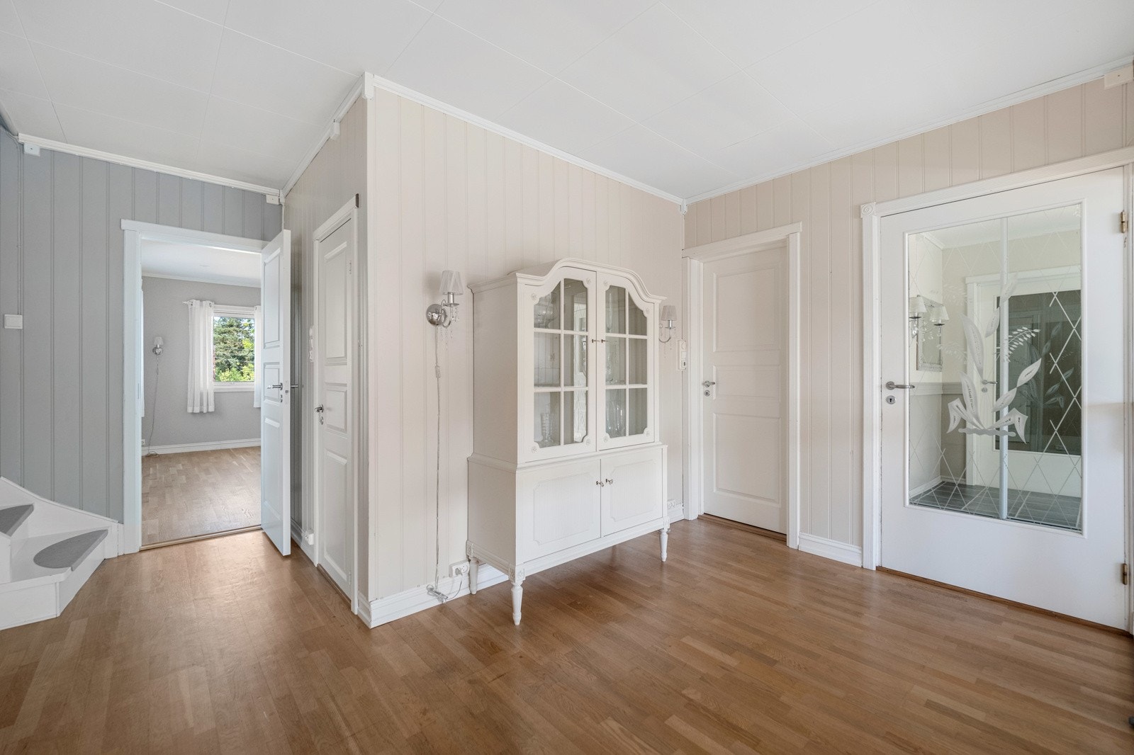 Spisestuen, stuen og trapperommet har et åpent og luftig areal. Det er parkettgulv og lysmalte panelvegger i rommet. Galleribilde