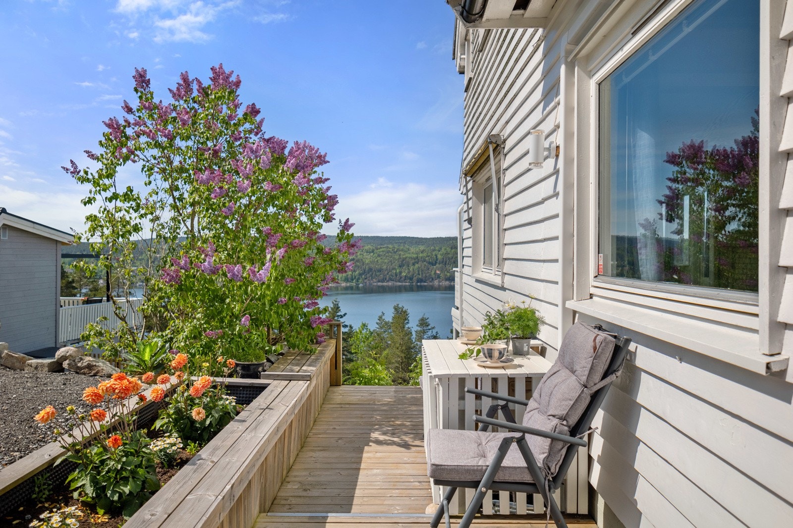 Det er flere plassbygde blomsterkasser og frodige prydbusker på tomten. Galleribilde