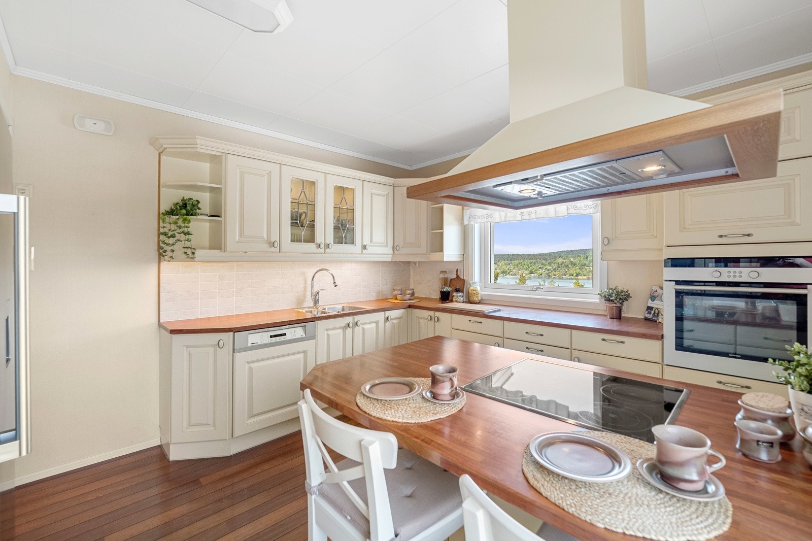 Kjøkkenet har profilert listverk, vitrineskap med blyglass og en barløsning med spiseplasser. Galleribilde