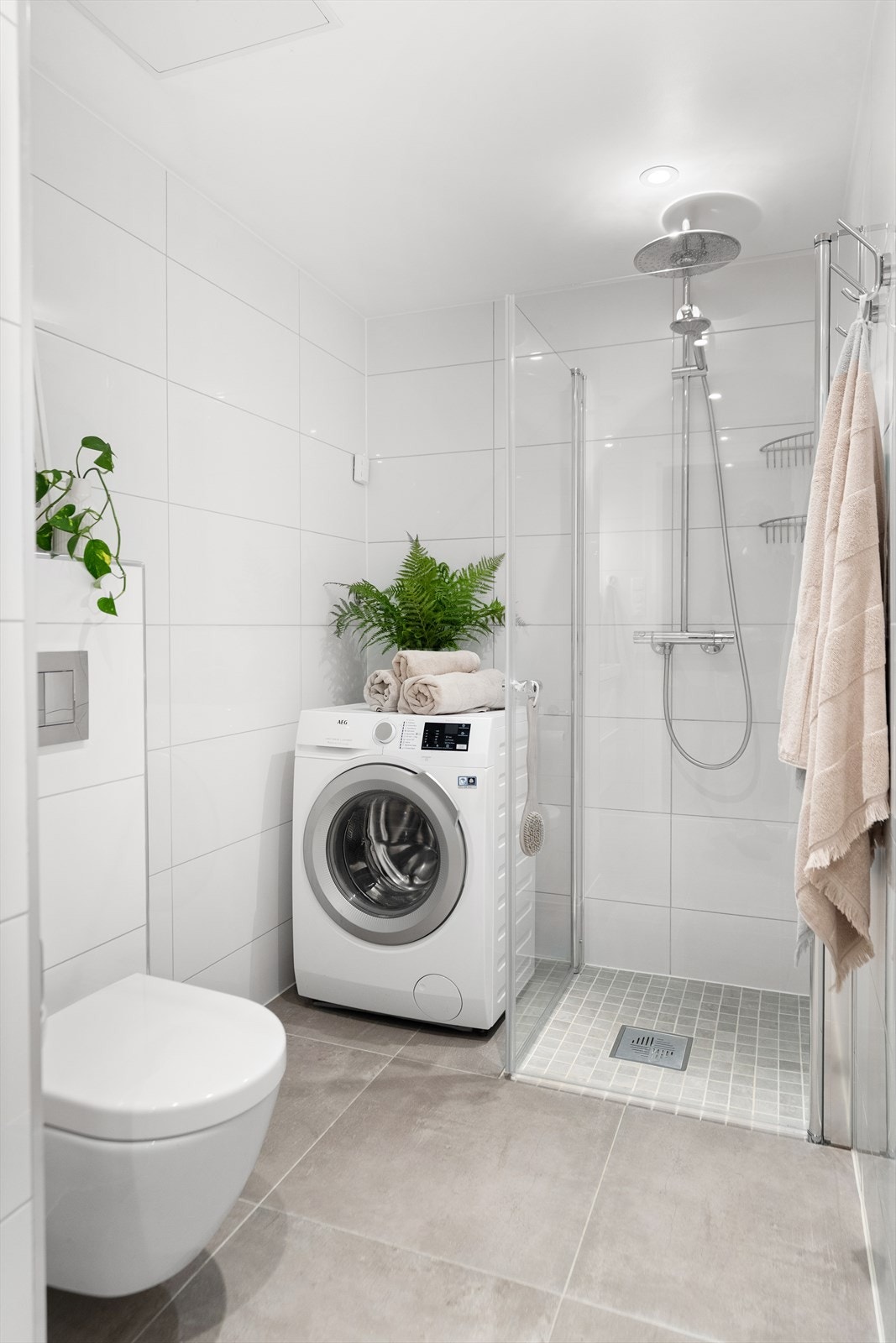 Moderne og delikat bad med fliser på gulv og vegger, gulvvarme og downlights som gir et stilrent preg. Galleribilde