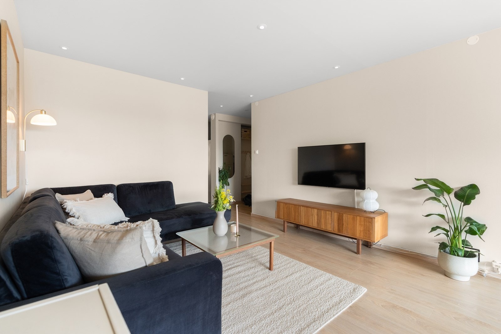 Leilighetens stue er lys og romslig, med vegger malt i en elegant, lys beigefarge. Galleribilde