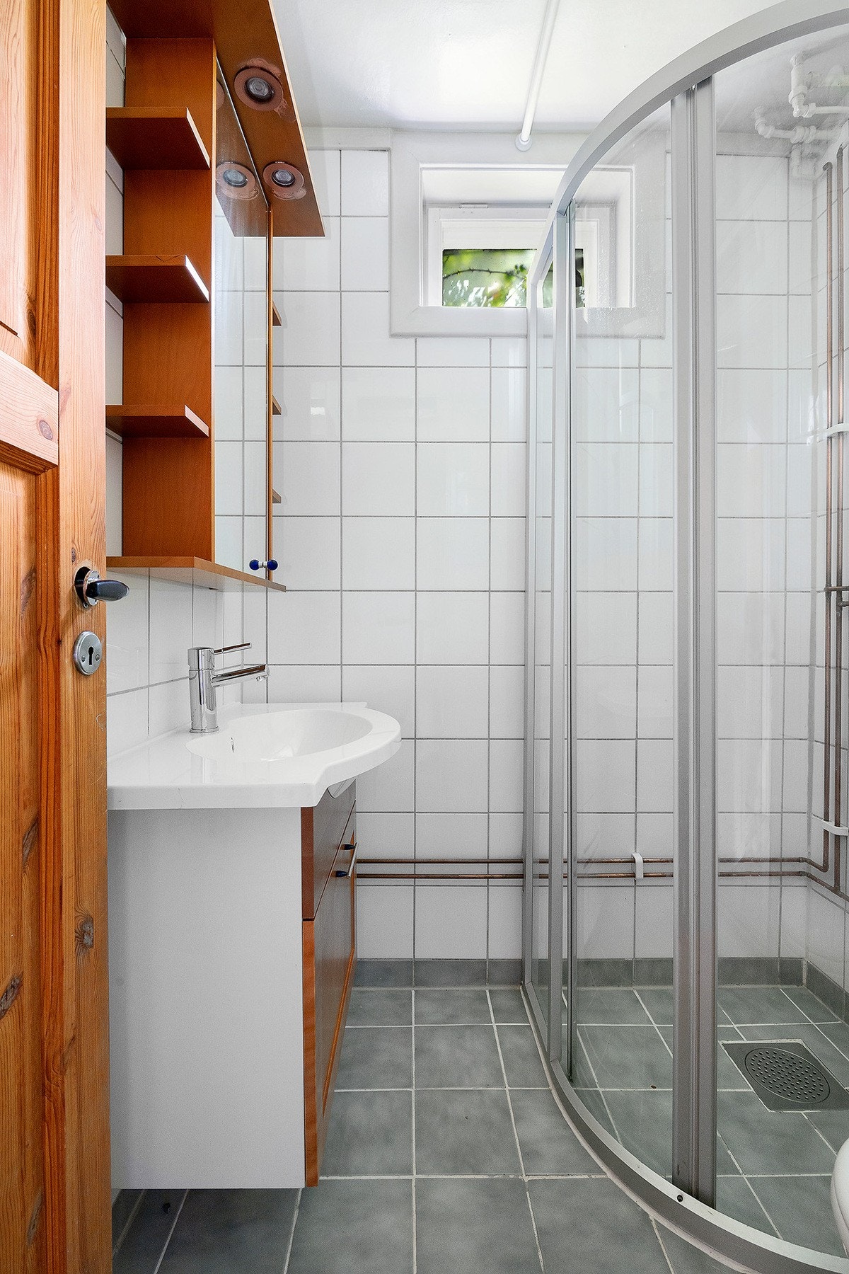 Badet i underetasjen har flislagte gulv og vegger - Her finner du dusjhjørne, frittstående toalett og servantskap Galleribilde