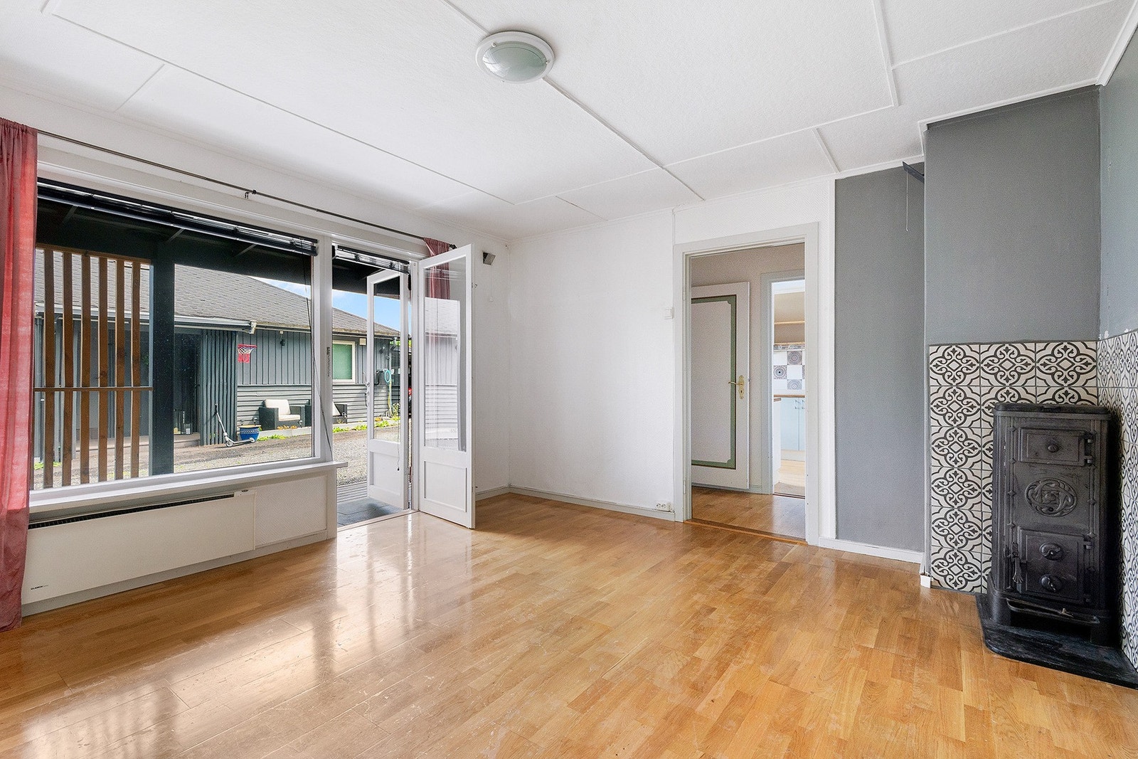 Underetasjen har en romslig stue med peisovn som byr på ekstra varme på kalde dager - Herifra er det også naturlig adkomst til boligens uteområder Galleribilde