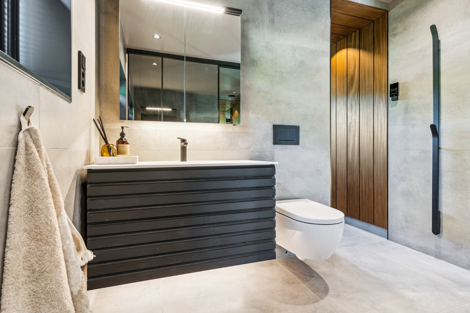 Lagring i både innredning og i speilskapet. Downlights i tak og håndkletørker på vegg. Toalettet er et spyletoalett. Galleribilde