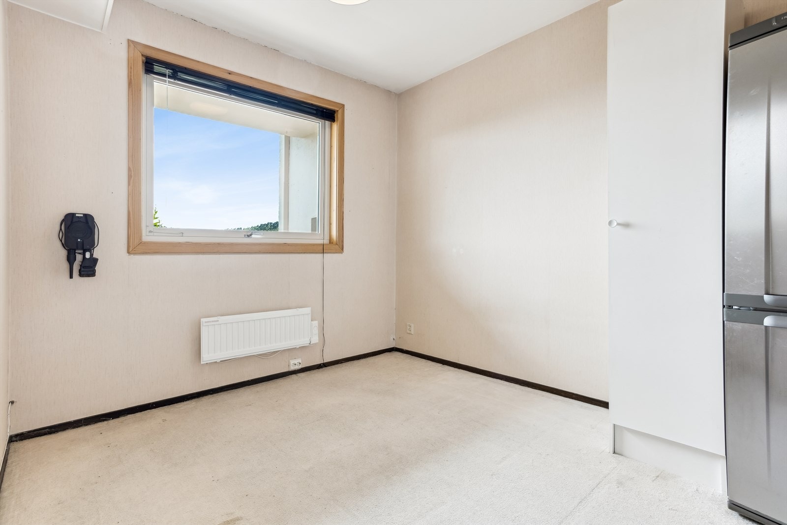 Romslig soverom på ca. 13,9 kvm med god plass til dobbeltseng, nattbord og garderobeløsning. Rommet har eldre teppe på gulv og slitt tapet på veggene, noe som gir en flott mulighet til å pusse opp etter egen smak. Galleribilde