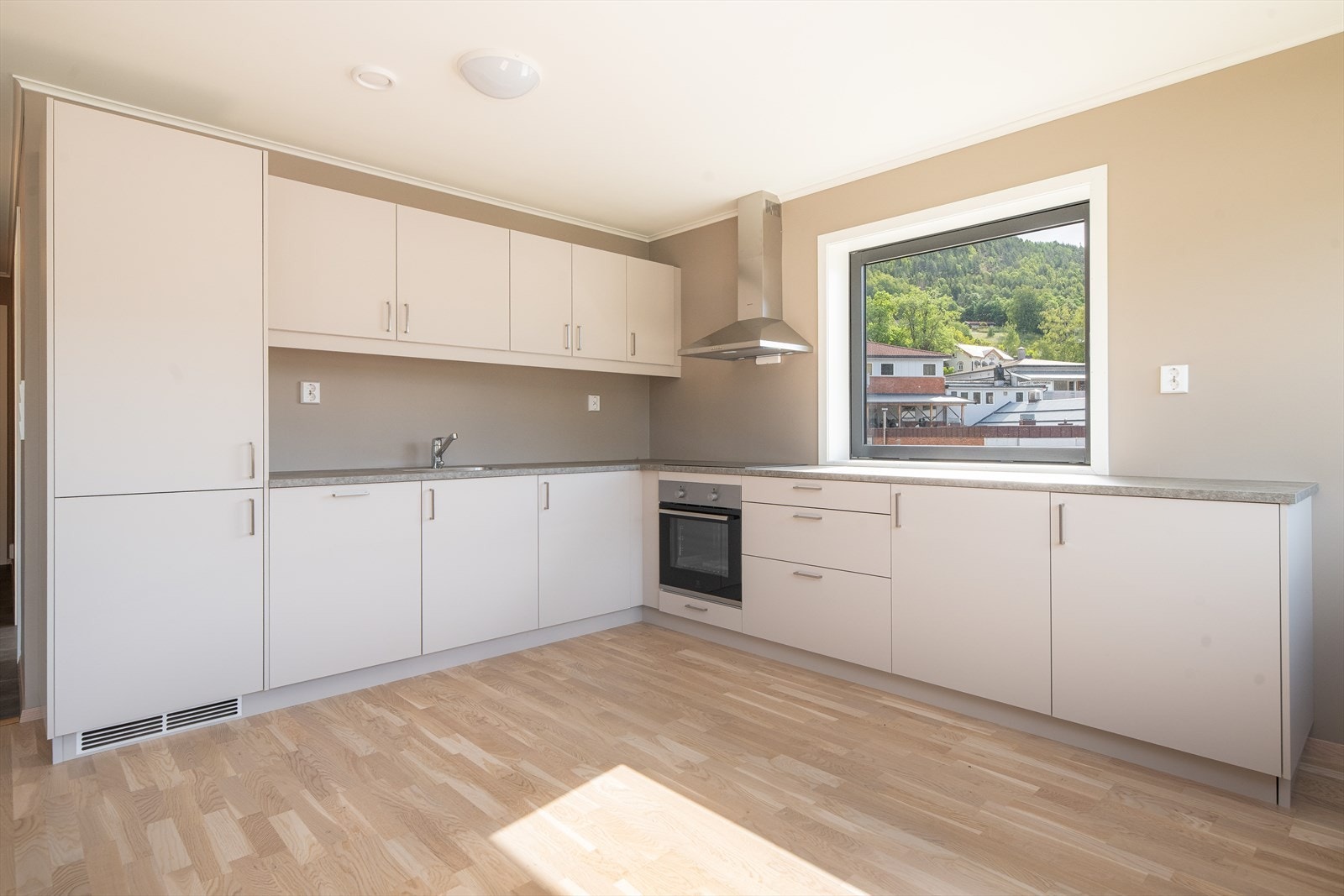 Stilrent kjøkken med gode arbeidsflater og integrerte hvitevarer. Det er god plass til spisebord på kjøkkenet Galleribilde