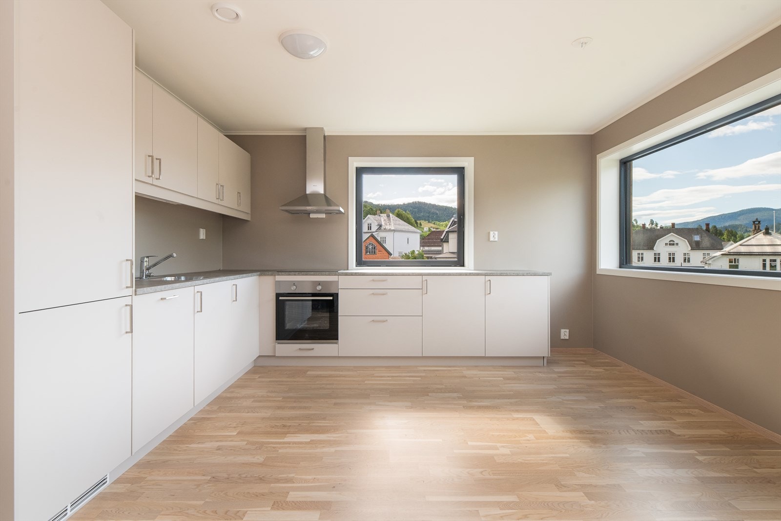 Kjøkken med gode vindusflater slipper lys og utsikt inn i boligen Galleribilde