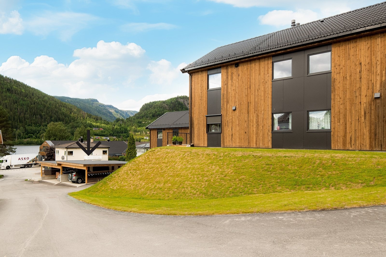 Til leiligheten følger det carport i felles carport anlegg som ligger rett ved leilighetsbygget. Se pil i bildet som viser carportene Galleribilde