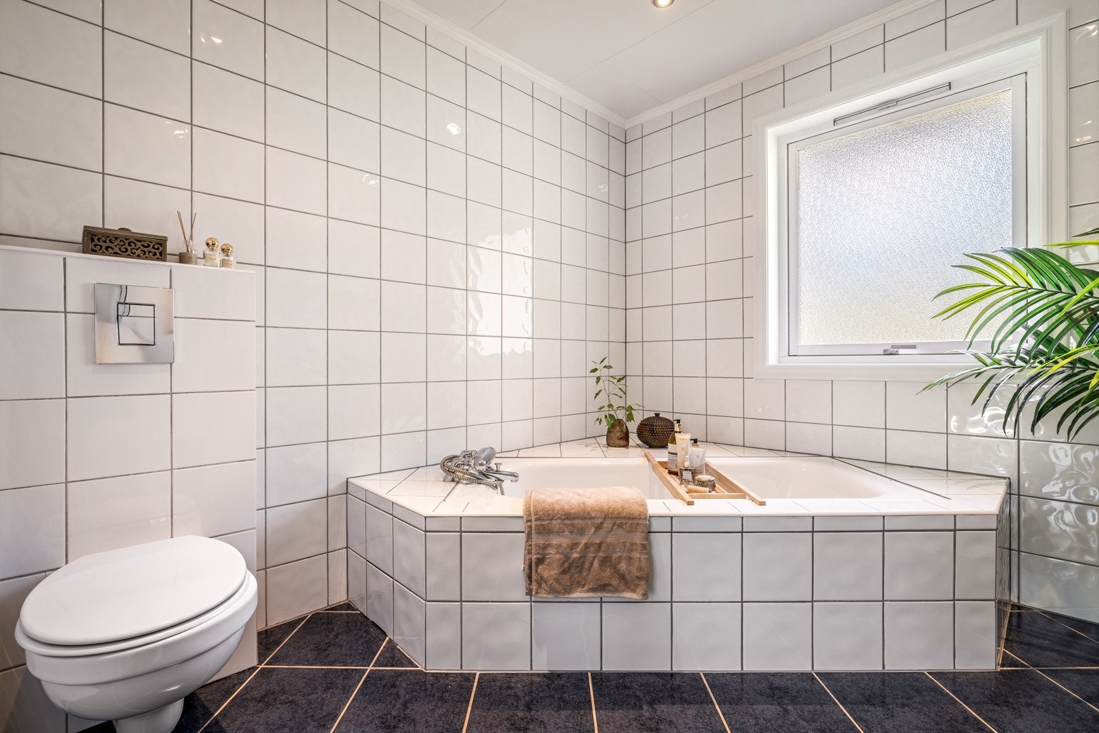 - Det er innredet med vegghengt toalett, innfliset badekar, søyle servant med overhengende speil og belysning - Galleribilde