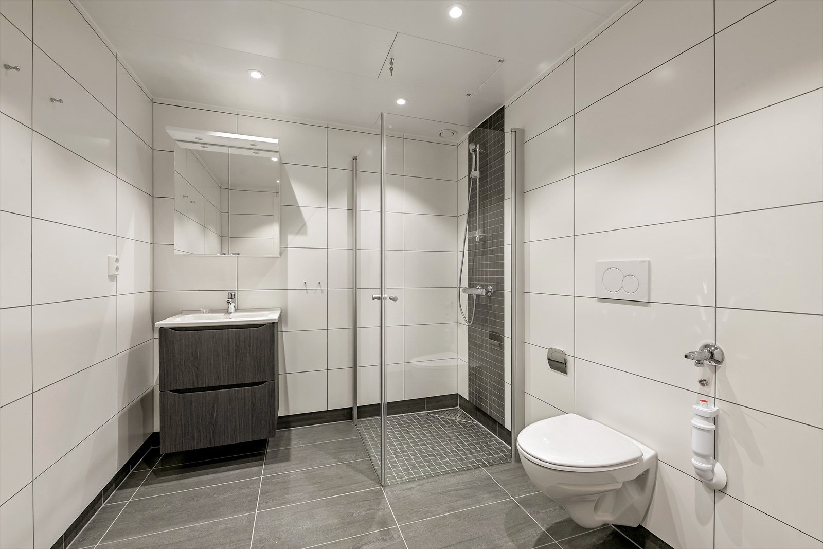 Badet er romslig og benyttes også som vaskerom. Flislagte vegger og gulv, med elektriske varmekabler. Galleribilde