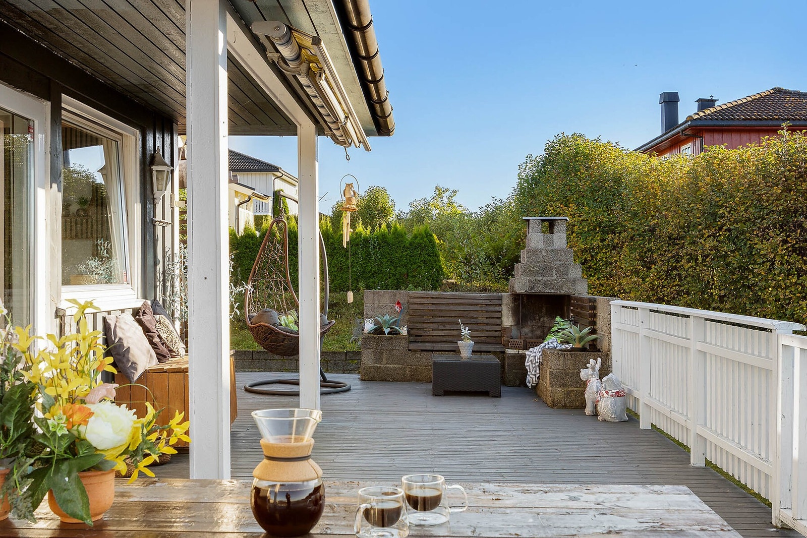 Terrassen har en skjermet beliggenhet med grønne busker. Galleribilde