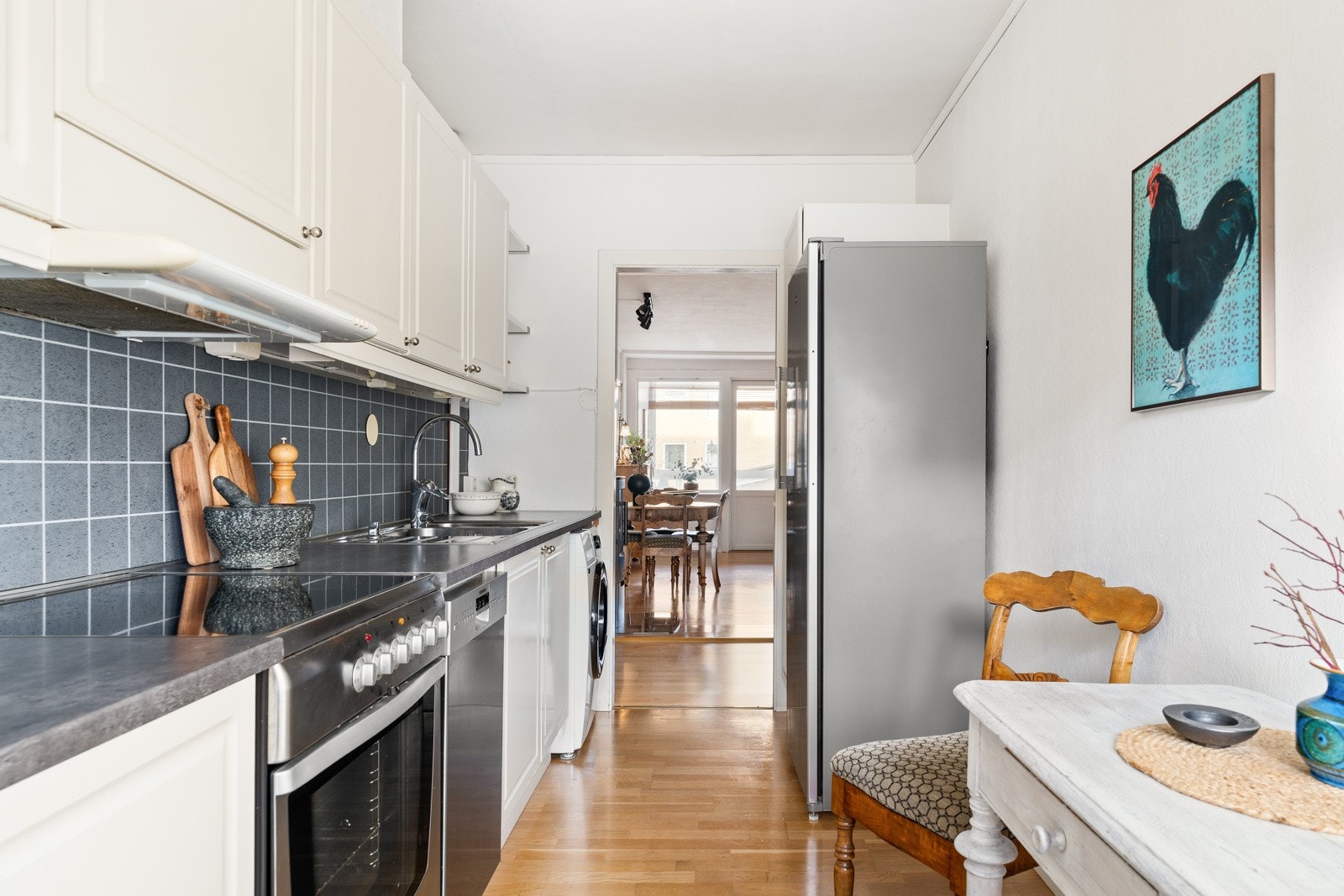 Kjøkkenet har en klassisk innredning med lyse, profilerte fronter og flislagt vegg over benkeplate. Galleribilde