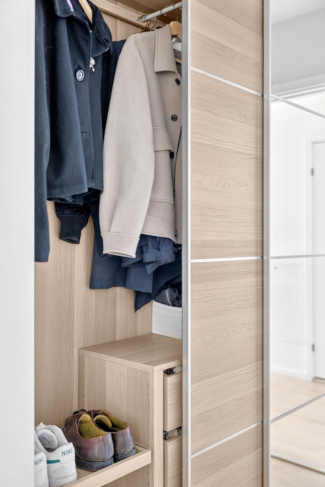Det er god plass til å henge fra seg ytterklær og sette fra seg sko i medfølgende skyvedørsgarderobe med eik- og speilfronter. Galleribilde