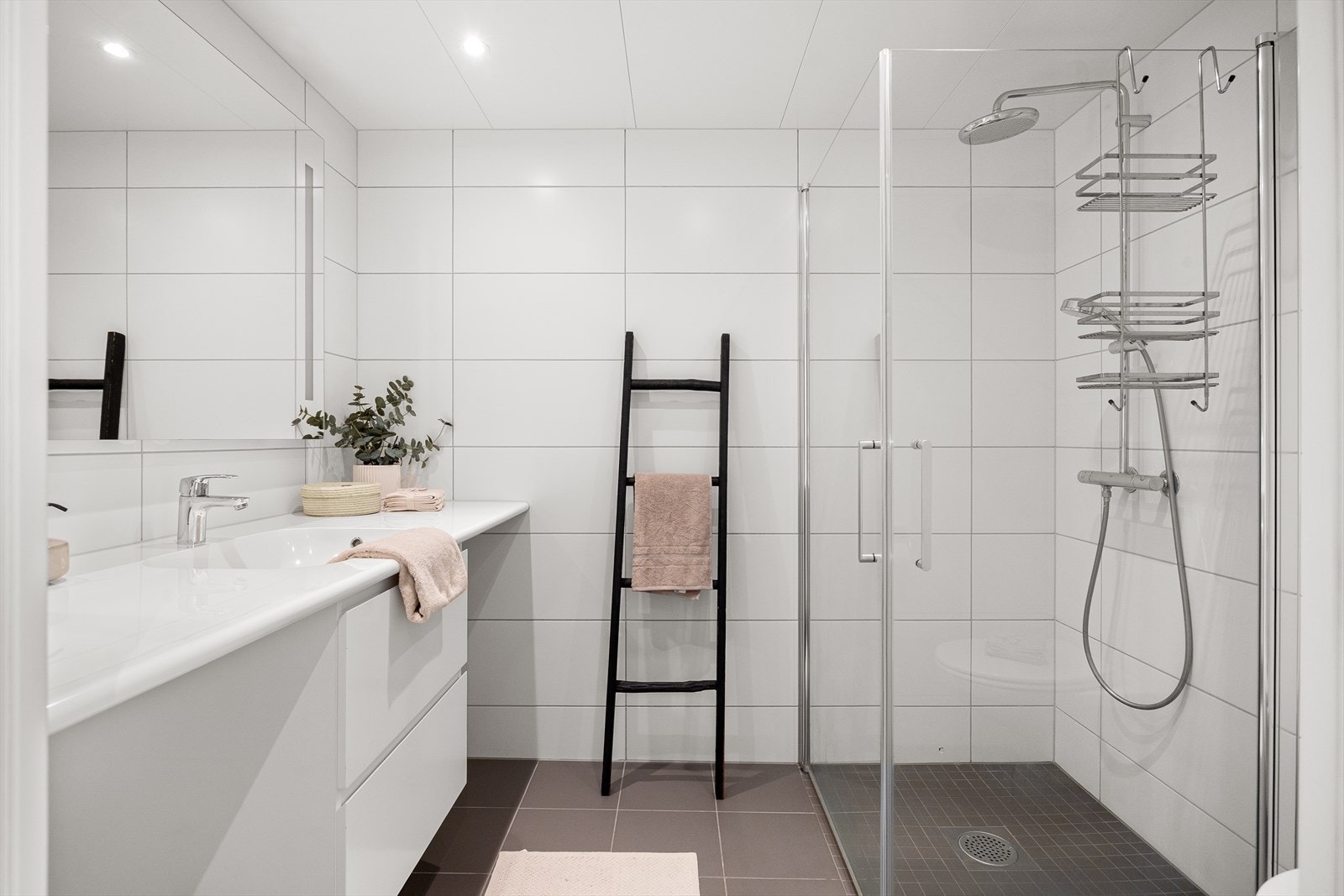 Pent, flislagt baderom med behagelig gulvvarme og downlights i himlingen. Det er tilrettelagt for både vaskemaskin og tørketrommel. Galleribilde