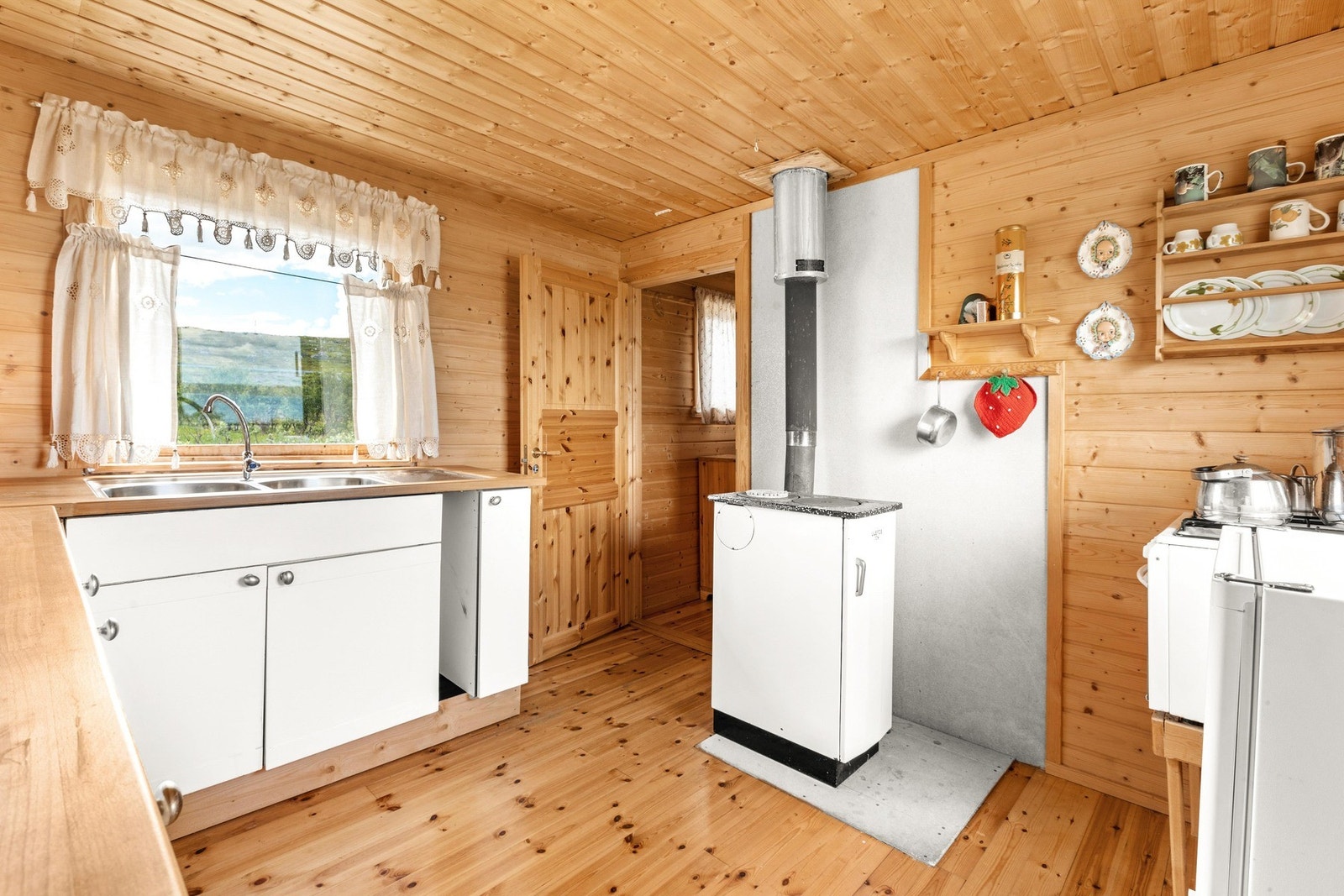 På kjøkkenet finner man også en vedfyrt ovn og hytten har sommervann via slange fra brønn Galleribilde