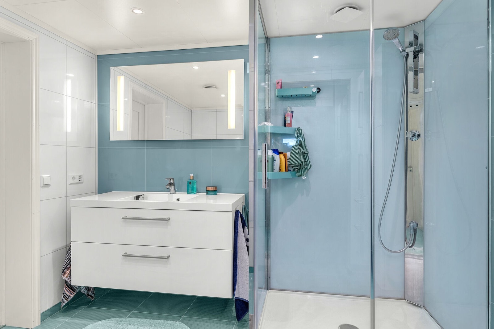 Badet har lys innredning med servant, lysspeil, dusjkabinett og toalett. Galleribilde