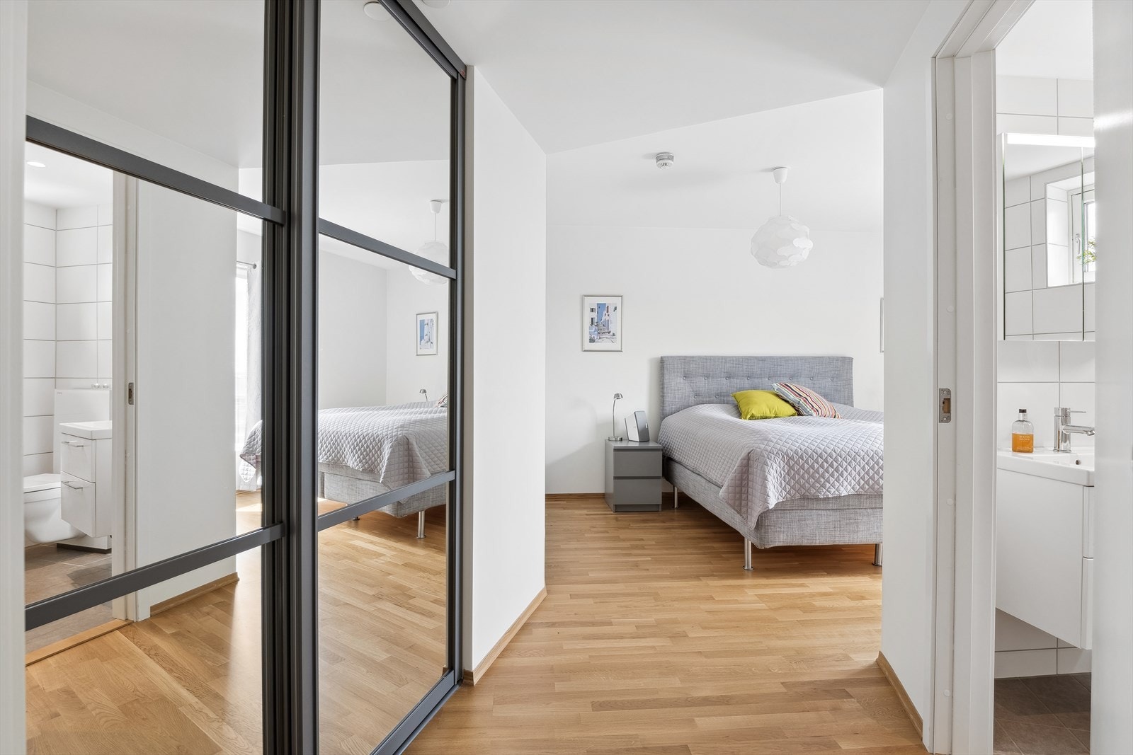 Leiligheten byr i alt på 2 luftige og romslige soverom med enkel anledning for å etablere 3 rom ved ønske og behov. Her ser vi bilde fra hovedsoverommet som har eget privat baderom og gode garderobeløsninger med Elfa garderobesystem. Galleribilde