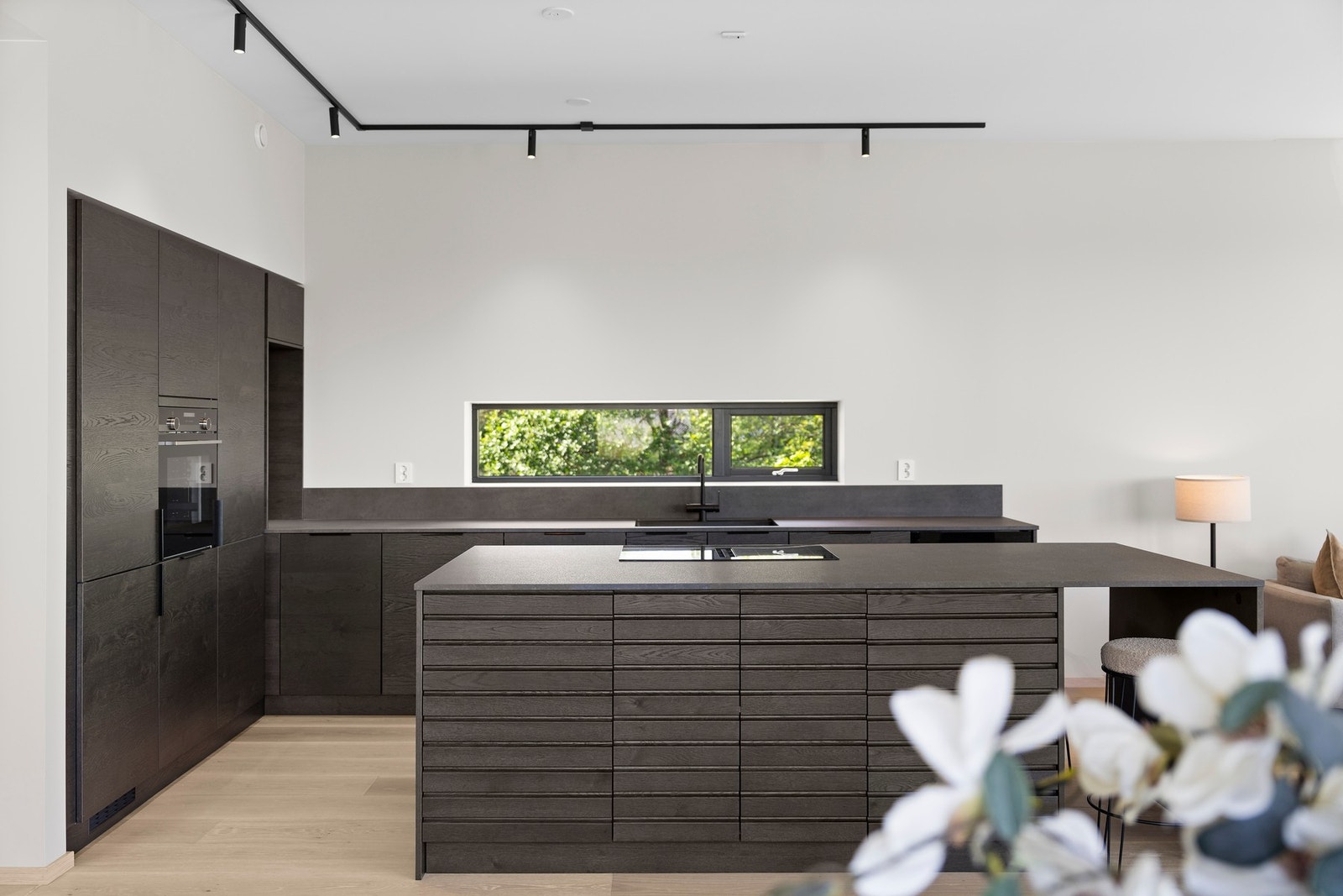 Kjøkkenet har kjøkkenøy som gir både praktisk oppbevaring og en sosial sone for matlaging. Galleribilde