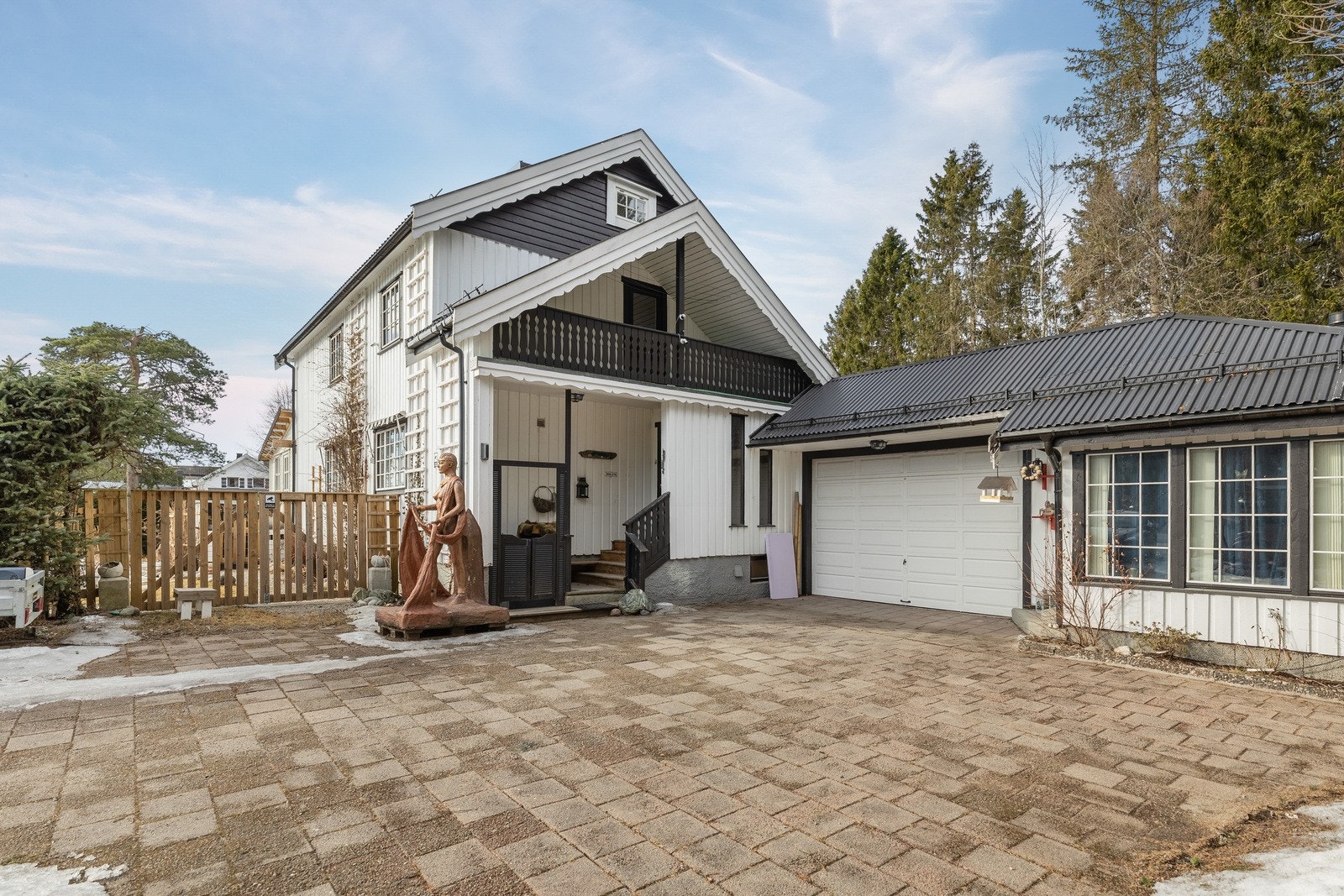 Stenbelagt gårdsplass med flere biloppstillingsplasser i tillegg til parkeringsmuligheter i garasje. Galleribilde