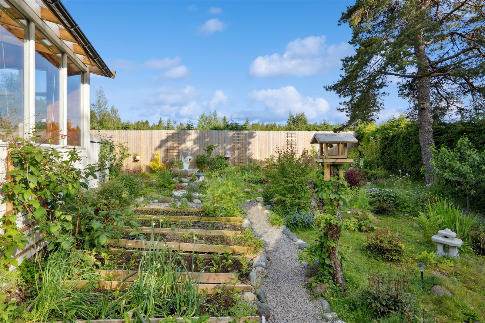 En unik og frodig hage med fiskedammer, stier, prydbusker, blomster, grønnsakshage m.m. Galleribilde