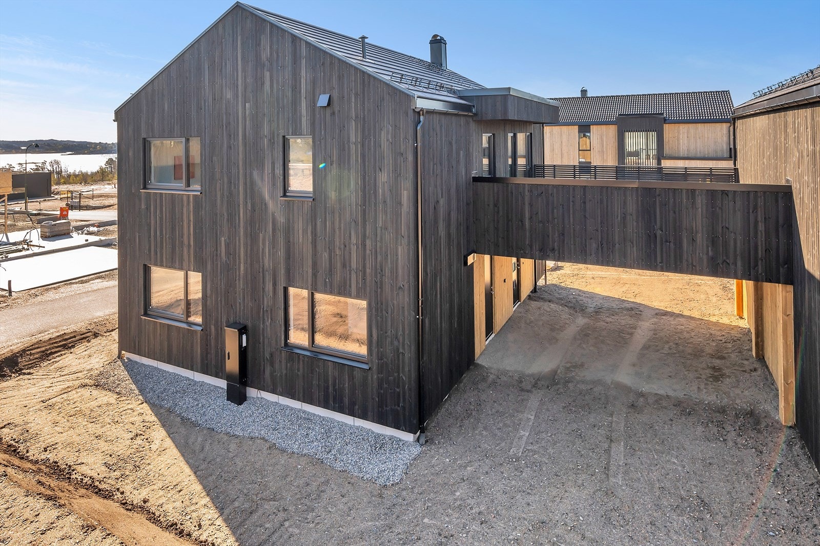 Moderne bolig med mørk fasade, romslig arkitektur og praktisk gjennomgang. Beliggende i naturskjønne omgivelser nær sjøen. Perfekt for familier. Galleribilde