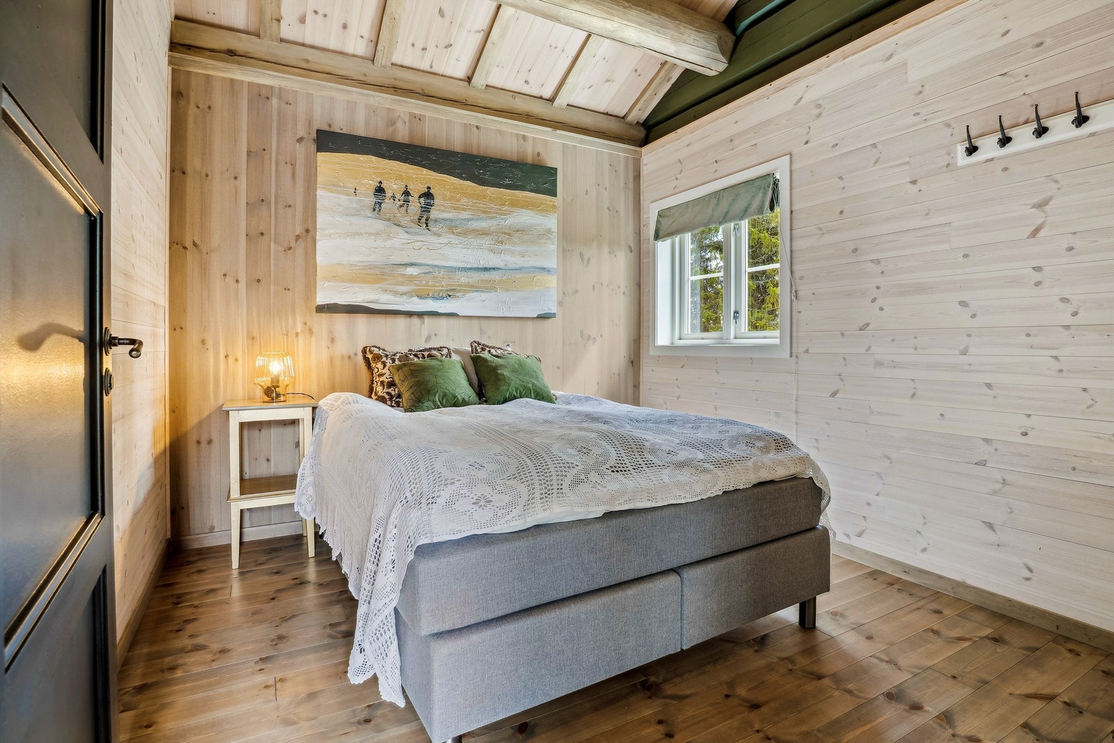 Romslig hovedsoverom med panelvegger og naturlig dagslys Galleribilde