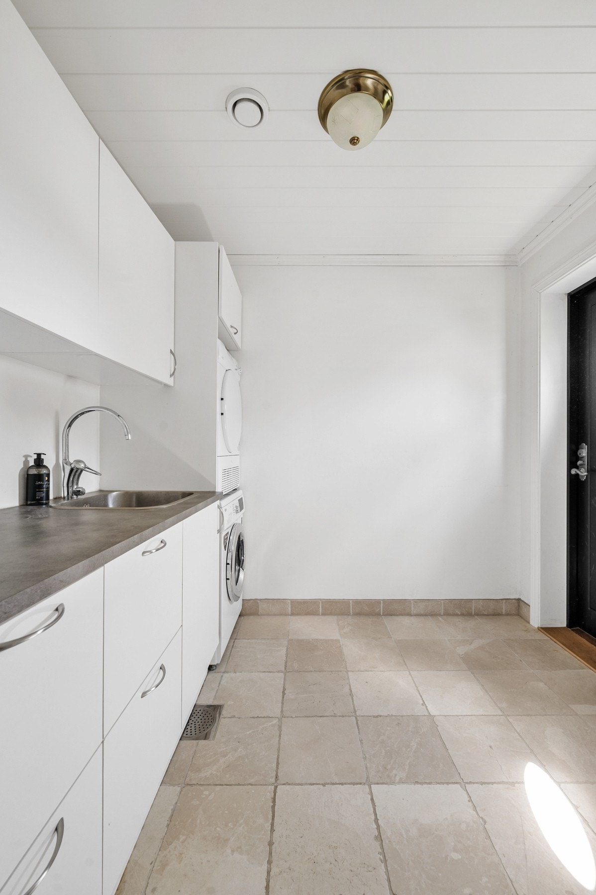 Praktisk vaskerom med egen inngang. Vaskerommet har nisje til vaskemaskin og tørketrummel, vask og benkeplate for enkel bretting av klær. Galleribilde